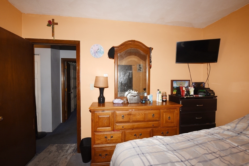 980 Plain Street, Unit 4 Marshfield, MA 02050 - Photo 20 of 26 a bedroom with a bed and a flat tv screen on dresser