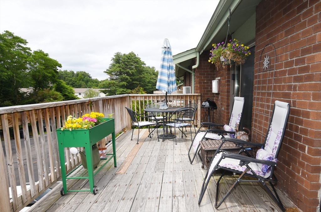 980 Plain Street, Unit 4 Marshfield, MA 02050 - Photo 23 of 26 a balcony with wooden floor table and chairs