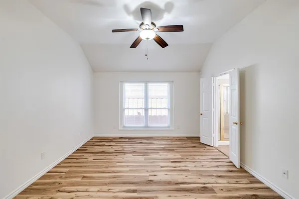 a view of empty room with window and ceiling fan