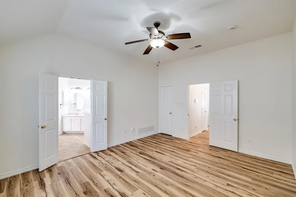 a view of empty room with wooden floor