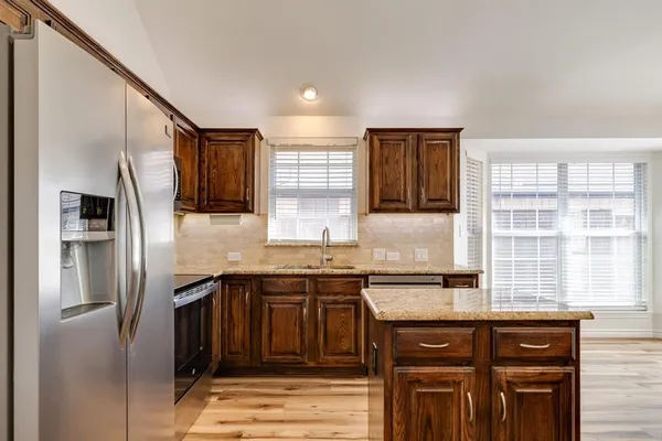 a kitchen with stainless steel appliances granite countertop a refrigerator and a sink