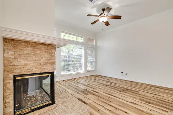 a view of an empty room with a fireplace and a window