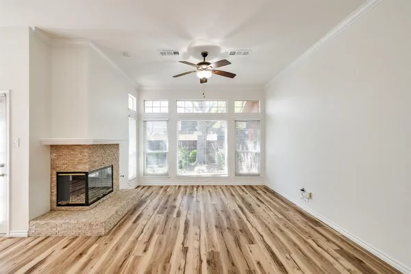a view of an empty room with a fireplace and a window