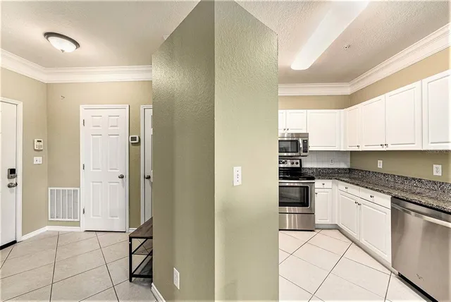 a kitchen with granite countertop white cabinets and white stainless steel appliances