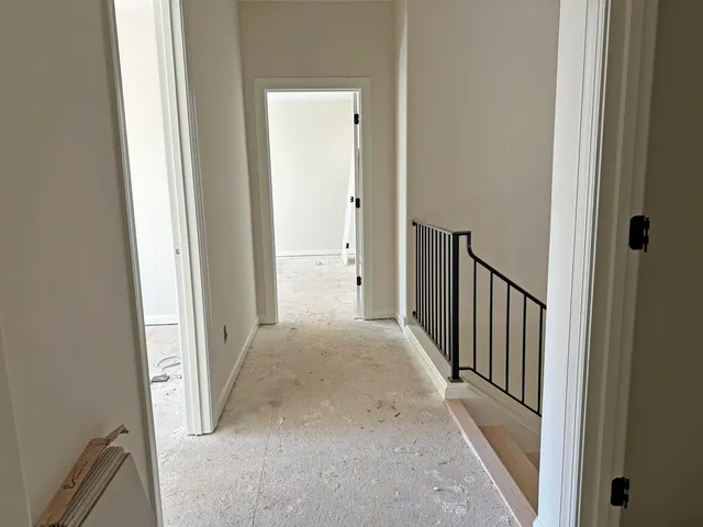 a view of a hallway with wooden floor and entryway