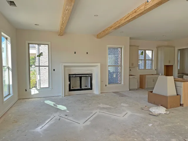 an empty room with windows and fireplace