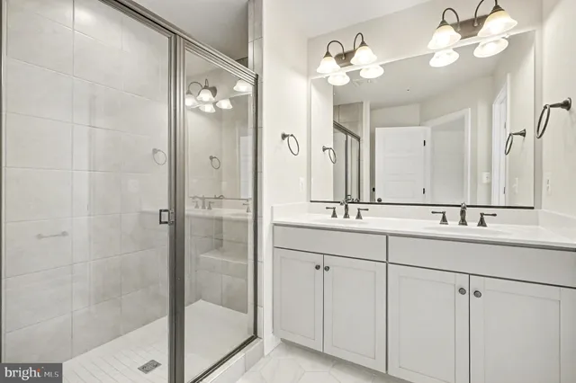 a bathroom with a double vanity sink mirror and shower