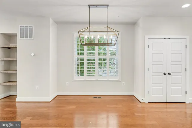 an empty room with cabinet and windows