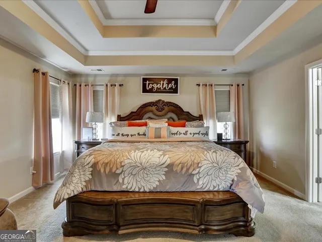 a spacious bedroom with a bed a couch and a ceiling fan