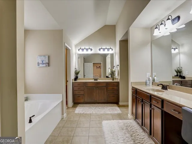 a bathroom with a tub a sink and a mirror