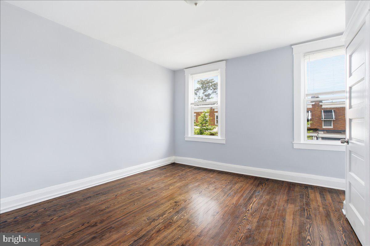 1231 North Potomac Street Baltimore, MD 21213 - Photo 12 of 25 a view of an empty room with wooden floor and a window