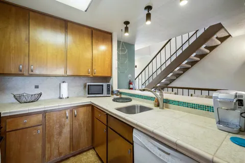 a kitchen with stainless steel appliances granite countertop a stove a sink and a microwave