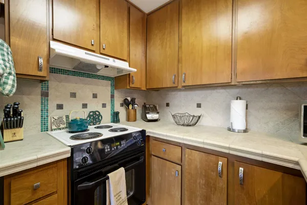 a kitchen with a sink a stove and cabinets