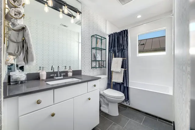 a bathroom with a granite countertop sink toilet and shower