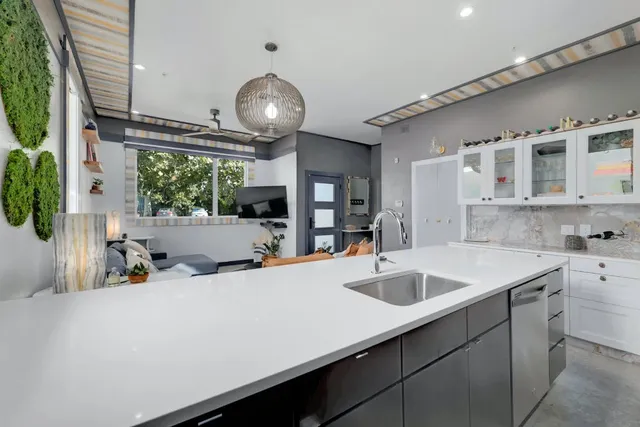 a kitchen with a sink a counter space appliances and cabinets