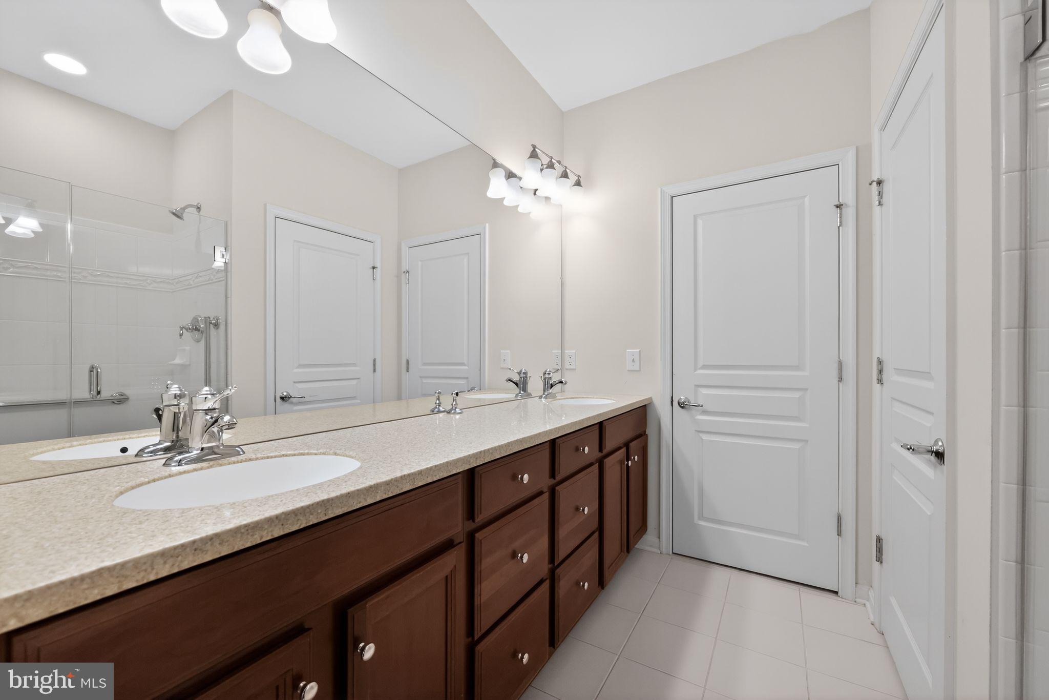 27 Stokes Avenue Voorhees, NJ 08043 - Photo 14 of 39 a bathroom with a double vanity sink a mirror and a bathtub
