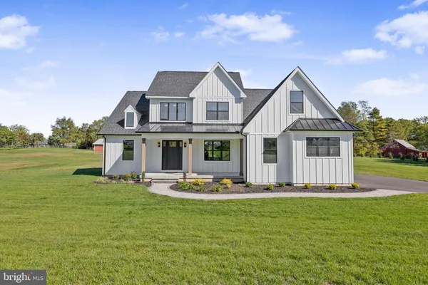a front view of house with yard and trees in the background