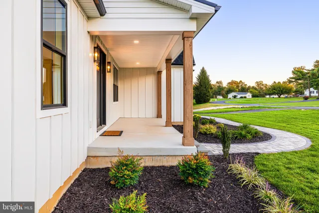a front view of a house with a yard and trees