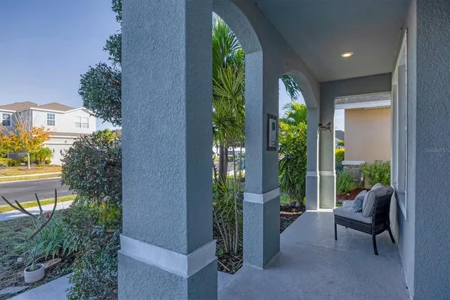a view of a porch with chairs and potted plants