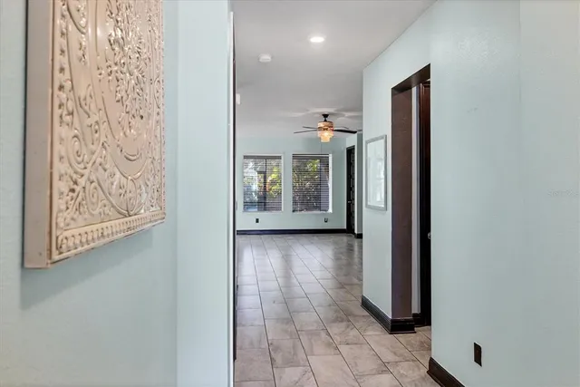 a view of a hallway with wooden floor and a living room