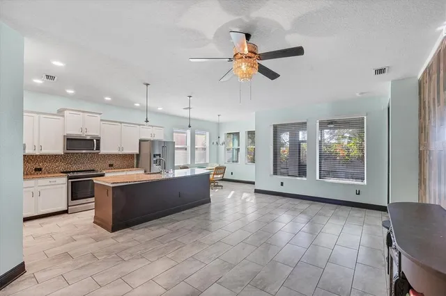a large kitchen with stainless steel appliances granite countertop a stove and a sink