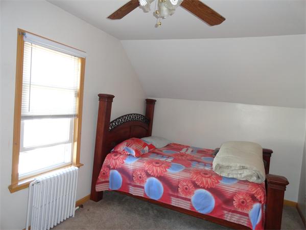 659 Cambridge Street Fall River, MA 02721 - Photo 18 of 18 a bedroom with a bed that has a blanket on it and next to a window