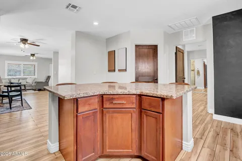 a kitchen with stainless steel appliances granite countertop a table chairs in it and wooden floors