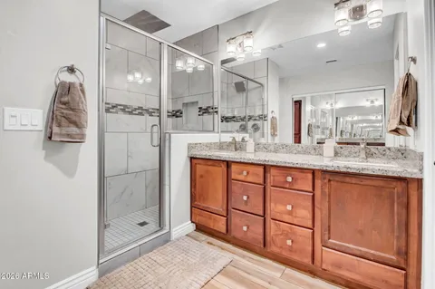a spacious bathroom with a granite countertop sink mirror and shower