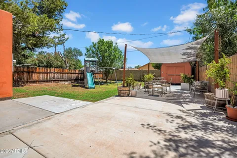 a view of a house with a yard and a large tree