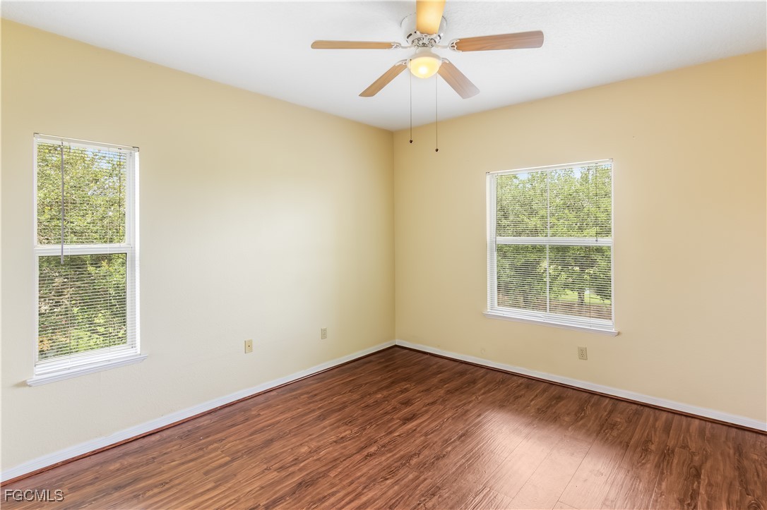 11490 Villa Grand, Unit 224 Fort Myers, FL 33913 - Photo 13 of 30 a view of an empty room with wooden floor and a window