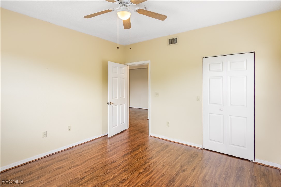 11490 Villa Grand, Unit 224 Fort Myers, FL 33913 - Photo 14 of 30 an empty room with wooden floor and windows
