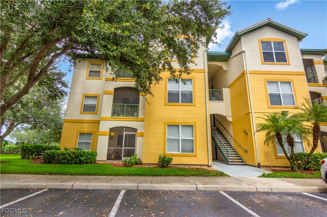 11490 Villa Grand, Unit 224 Fort Myers, FL 33913 - Photo 27 of 30 a front view of a house with a yard and trees
