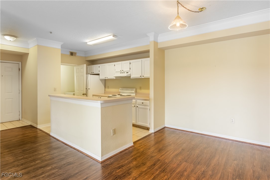11490 Villa Grand, Unit 224 Fort Myers, FL 33913 - Photo 4 of 30 a kitchen with kitchen island a sink and wooden floor