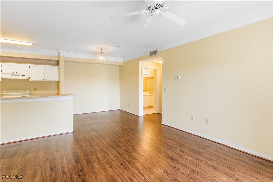 11490 Villa Grand, Unit 224 Fort Myers, FL 33913 - Photo 5 of 30 a view of a kitchen with wooden floor and a ceiling fan