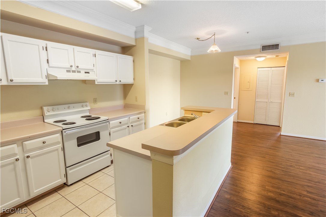 11490 Villa Grand, Unit 224 Fort Myers, FL 33913 - Photo 6 of 30 a kitchen with a sink a stove and cabinets