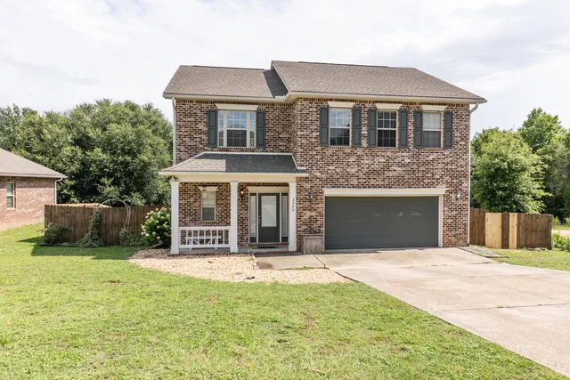 a front view of a house with yard and garage