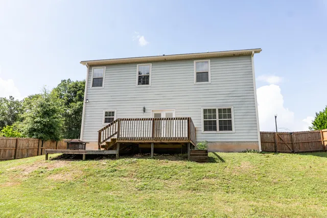 a backyard of a house with yard table and chairs