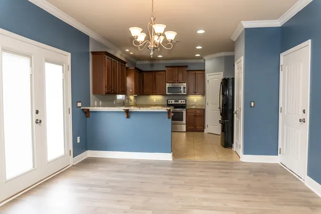 a view of a kitchen with stainless steel appliances granite countertop a refrigerator and a sink