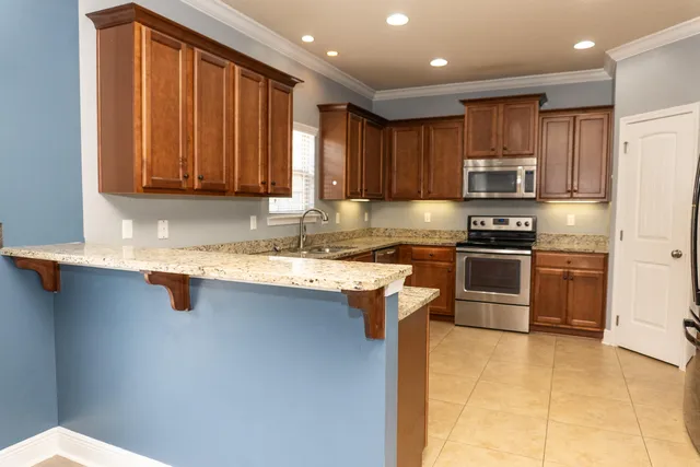 a kitchen with stainless steel appliances granite countertop a sink stove and refrigerator