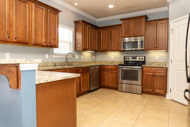 a kitchen with stainless steel appliances granite countertop a stove a sink dishwasher and a refrigerator