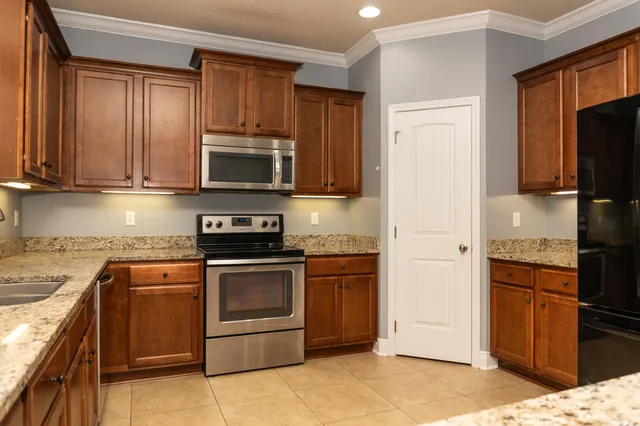 a kitchen with granite countertop wooden cabinets and stainless steel appliances