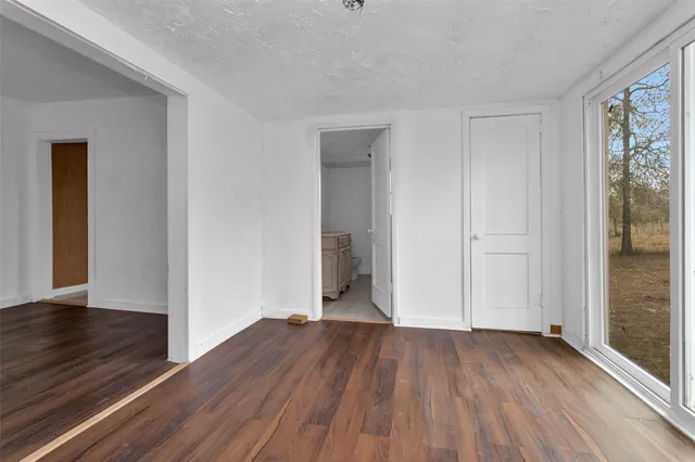 an empty room with wooden floor and closet