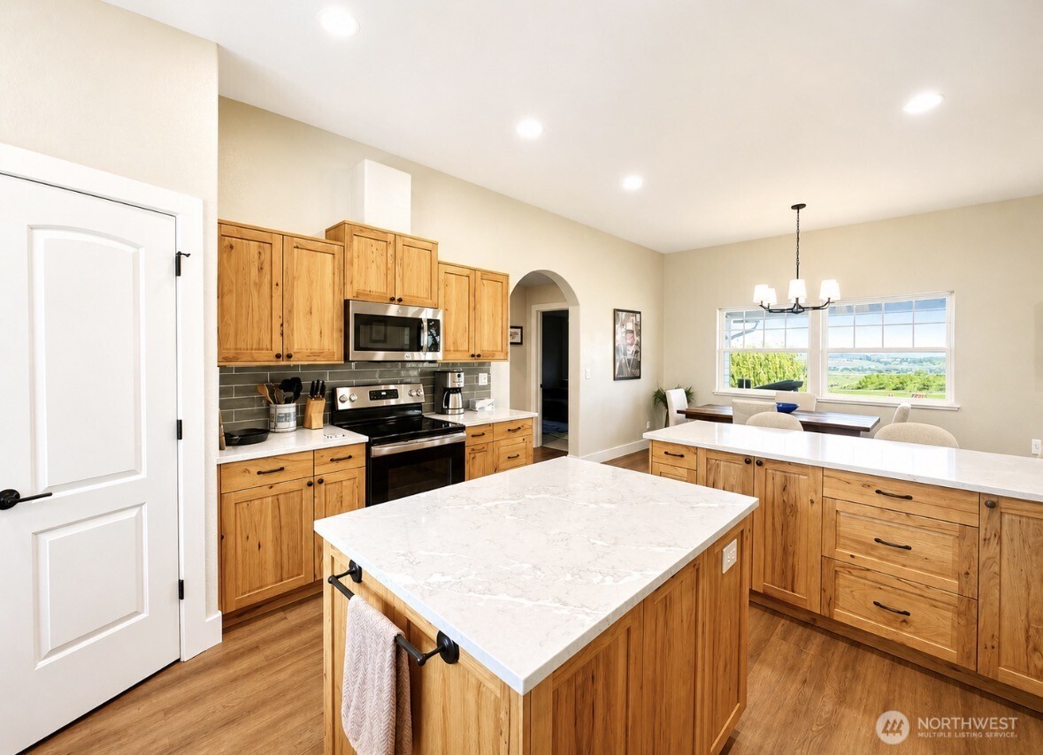 22 Rooster Flats Road Oroville, WA 98844 - Photo 14 of 28 a kitchen with white cabinets and stainless steel appliances