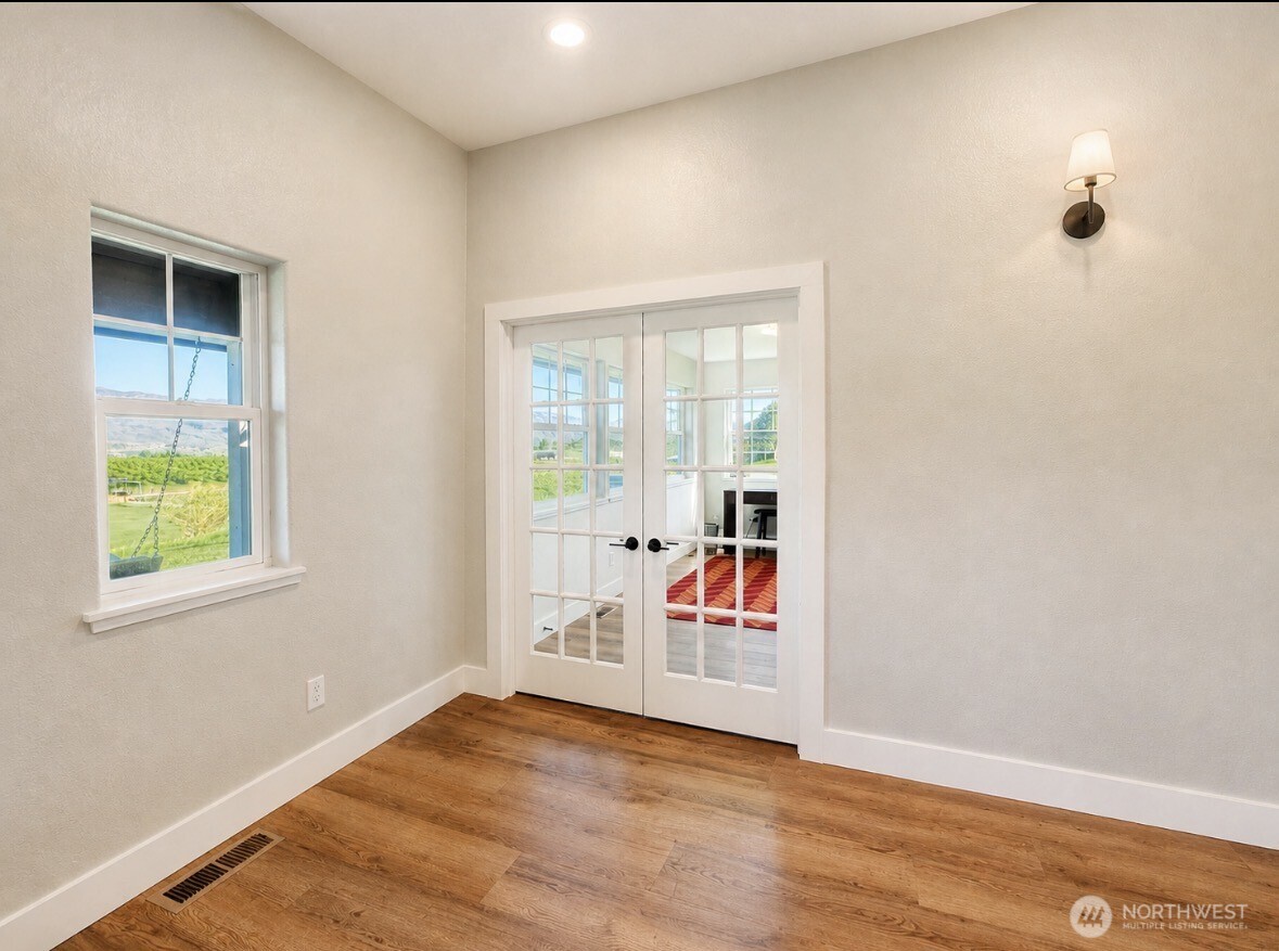 22 Rooster Flats Road Oroville, WA 98844 - Photo 7 of 28 an empty room with window and wooden floor