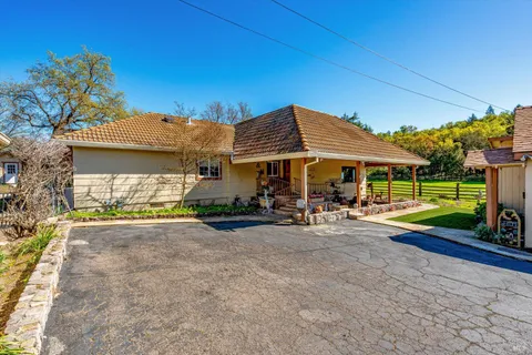 a view of a house with backyard and sitting area