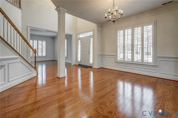 a kitchen with stainless steel appliances granite countertop a stove top oven a sink dishwasher a refrigerator and a dining table with wooden floor