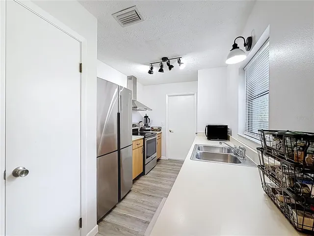 a kitchen with kitchen island a counter top space and stainless steel appliances