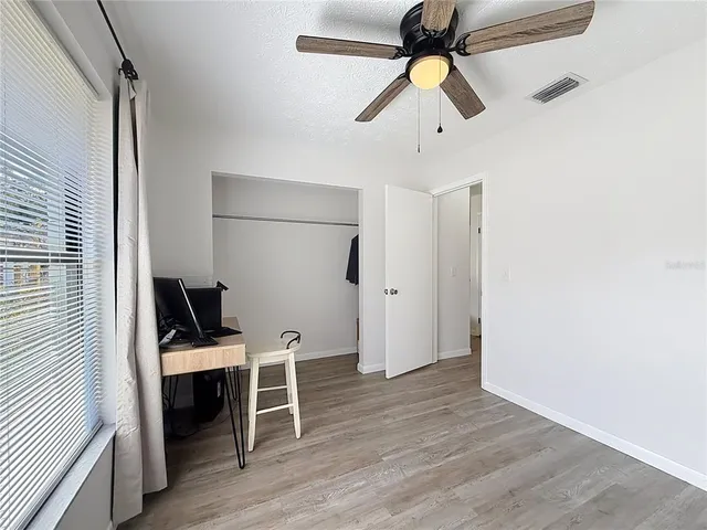 a view of a workspace with furniture and a window