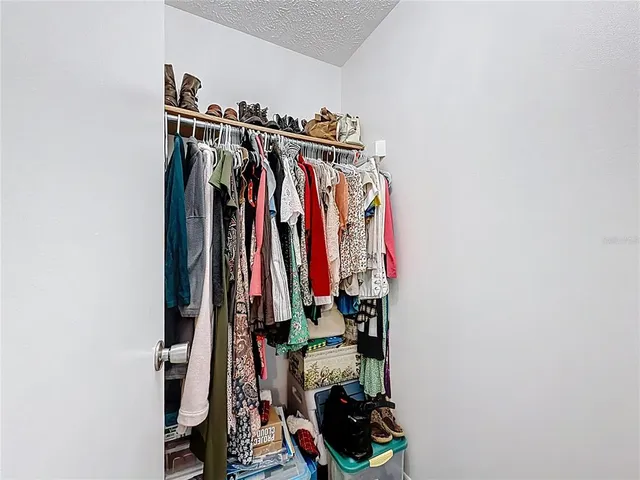 a view of walk in closet with clothes and shoes