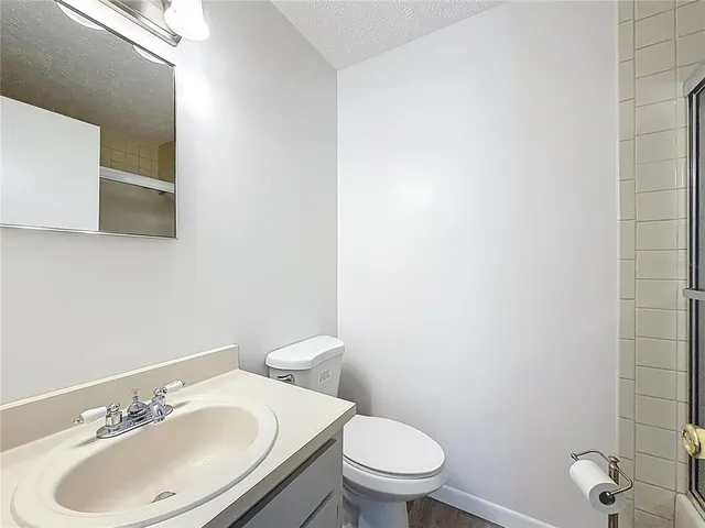 a bathroom with a sink a toilet and a mirror
